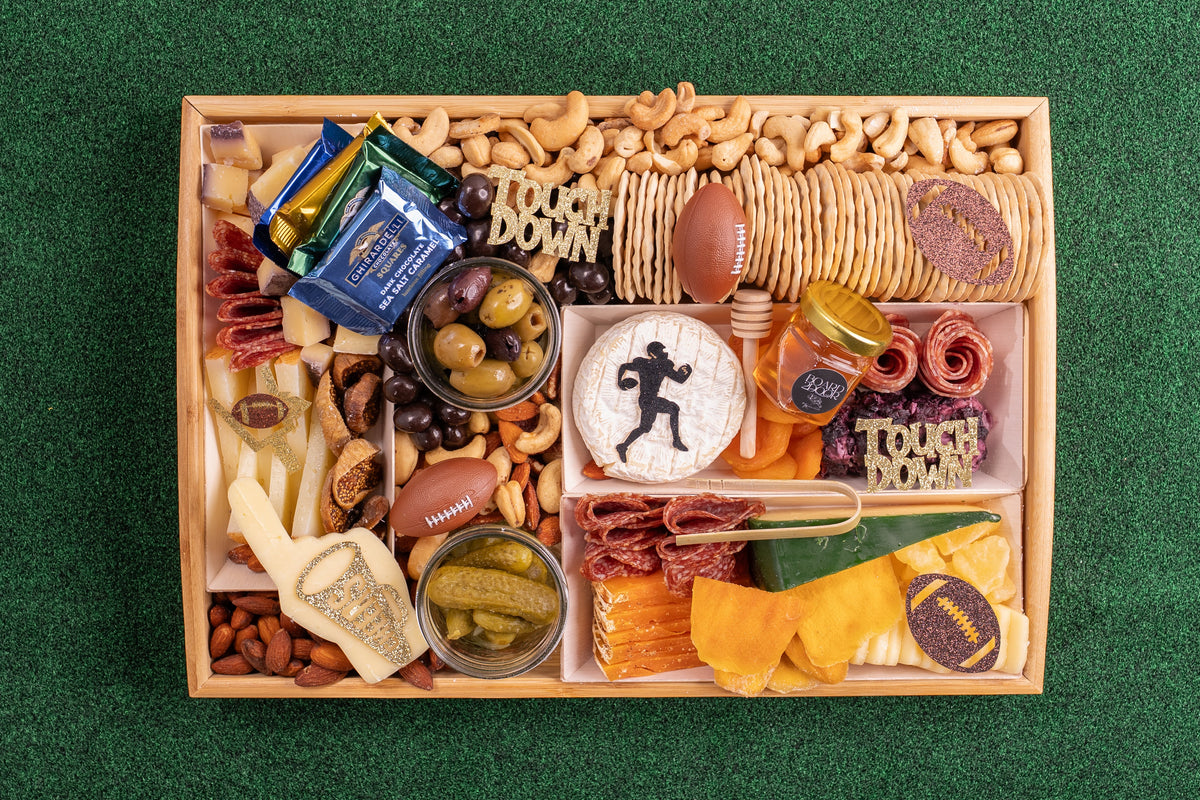 Gourmet snack box with various food items on a green background